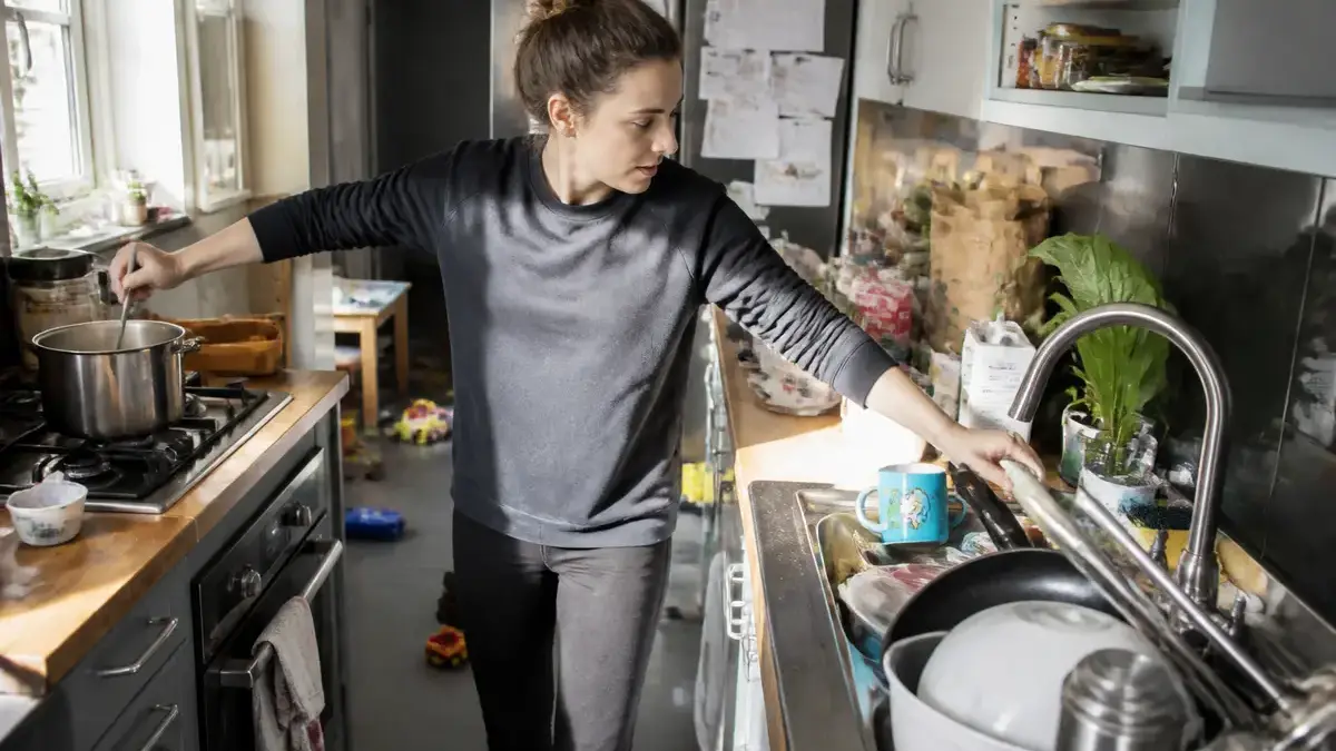 Femme gérant des tâches domestiques, illustrant la charge mentale au quotidien