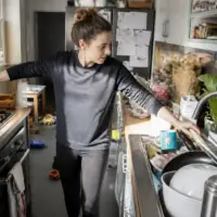 Femme gérant des tâches domestiques, illustrant la charge mentale au quotidien