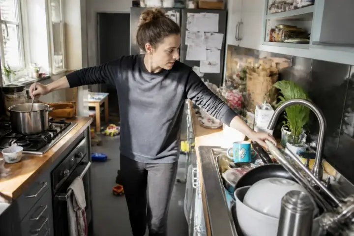 Femme gérant des tâches domestiques, illustrant la charge mentale au quotidien